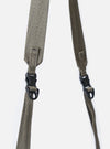 Close-up of the F/CE.® Charcoal Nylon Textured Twill Drawstring Sacoche strap. The strap is a textured, woven nylon in a muted charcoal color with black plastic buckles. Shot on a white background.