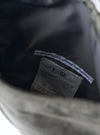 Close-up of the inside of the F/CE.® Charcoal Nylon Textured Twill Drawstring Sacoche, showing the textured nylon lining and brand label. 