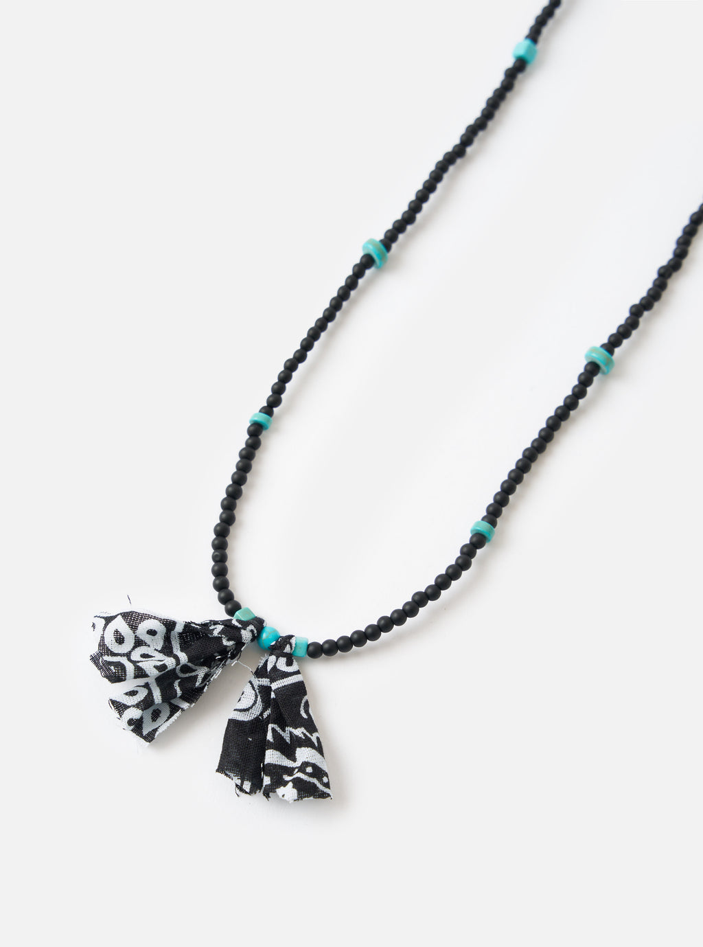 Hanami of Rome Matte Black/Turquoise Bead Necklace No.58 on a white surface. Features black beads, turquoise accents, and black/white patterned fabric tassels.