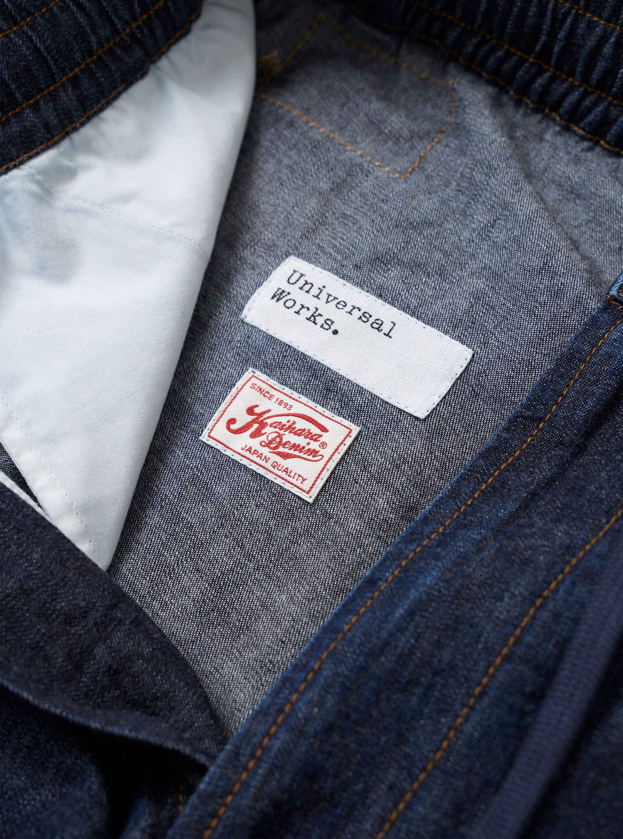 The Indigo Kaihara LT WT Denim Hi Water Trouser is shown as a flat lay against a plain white background. The trousers feature an elasticated waistband with a drawstring, a relaxed fit through the leg, and a cropped hem. The garment is made from a lightweight indigo blue denim fabric with visible seam detailing.