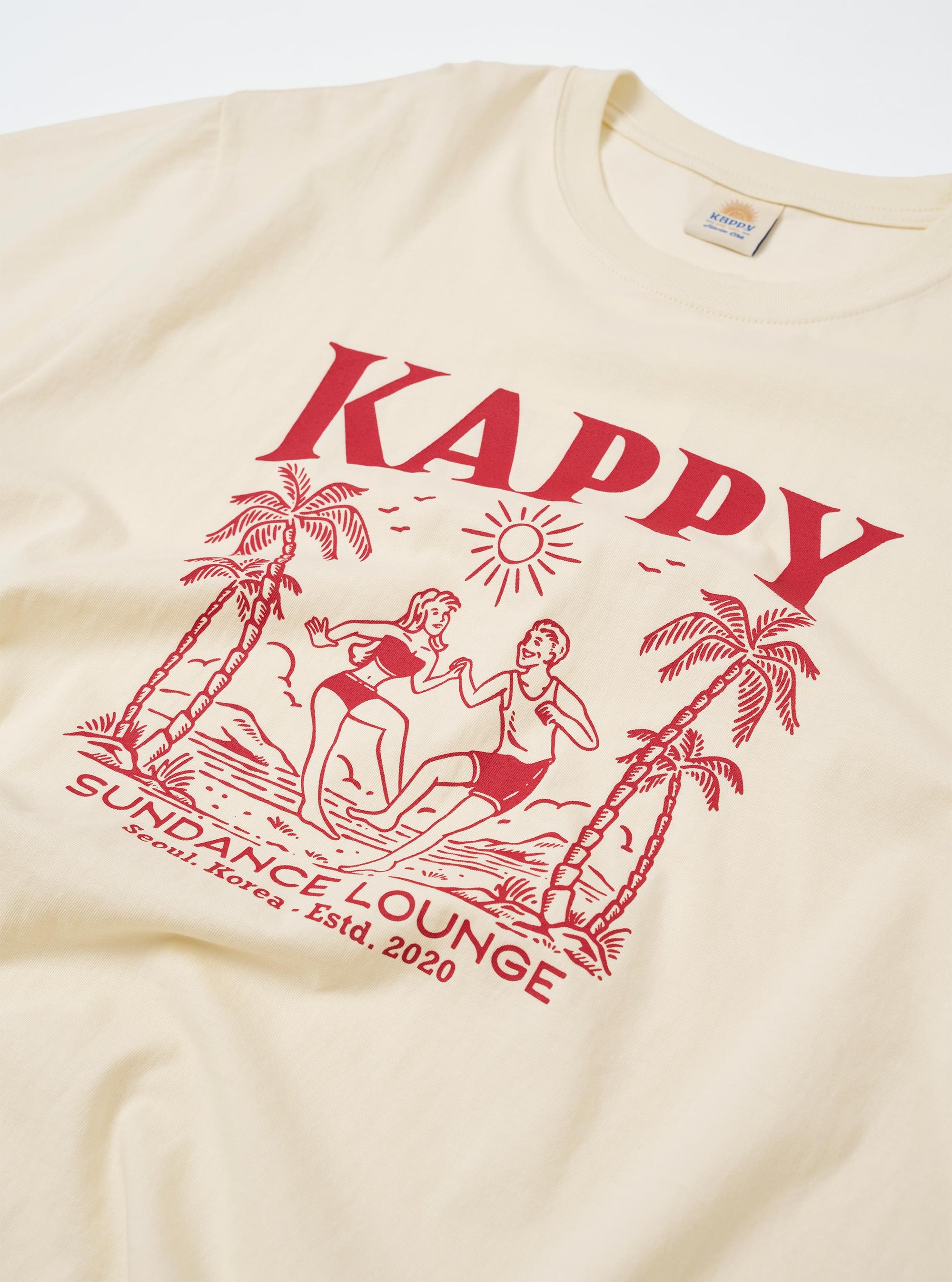 The Kappy Cream Sundance Lounge Half Tee is shown from a rear angle as a flat lay against a plain white background. The image highlights the oversized, boxy fit and the clean, wide-cut sleeves of the cream-colored cotton garment.