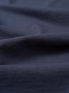 A close-up fabric swatch of the Kappy Vintage Navy Sunny Wink Half Tee highlights the vintage navy blue color and the texture of the cotton fabric. The image provides a detailed view of the material and the Sunny Wink design element.