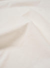A close-up swatch image of the Kappy White Sunny Wink Half Tee highlights the white cotton fabric and the detail of the graphic print. The material fills the frame, providing a detailed view of the garment's color and texture.