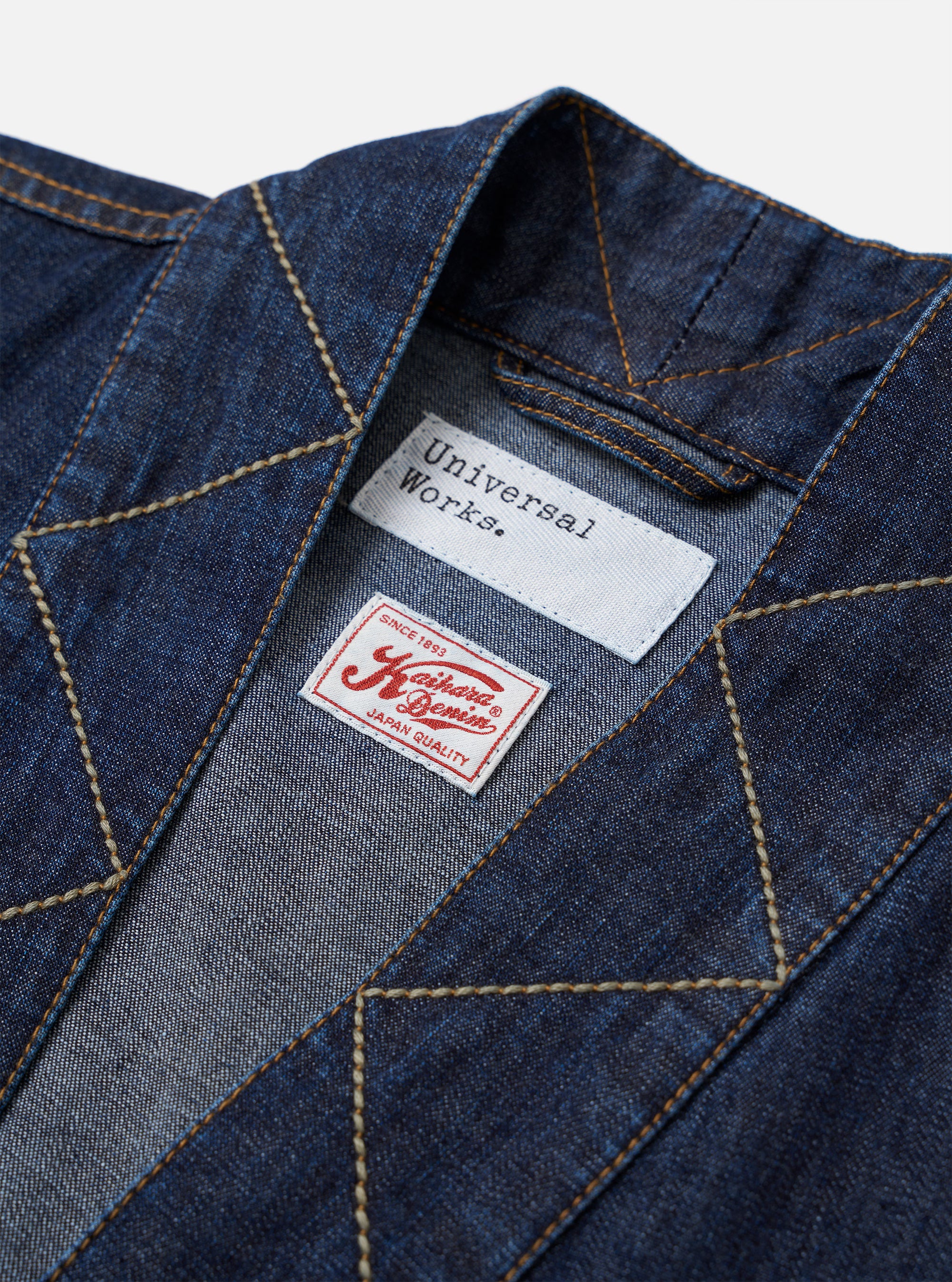 The Indigo Kaihara LT WT Denim Kyoto Work Jacket is shown as a flat lay against a plain white background. The jacket features a kimono-style wrap front with internal and external fabric ties for closure. It is designed with one external chest patch pocket and two larger patch pockets at the waist. The lightweight indigo-dyed denim has a smooth, consistent finish with visible tonal stitching.