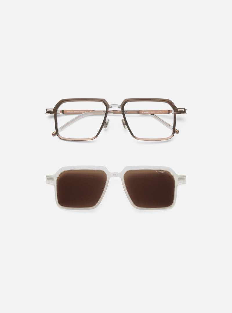 A. SOCIETY x Universal Works Brown/Honey Kowloon Eyewear on a white surface. The glasses have a brown and honey-colored frame. Below are sunglasses with a white frame and brown lenses.