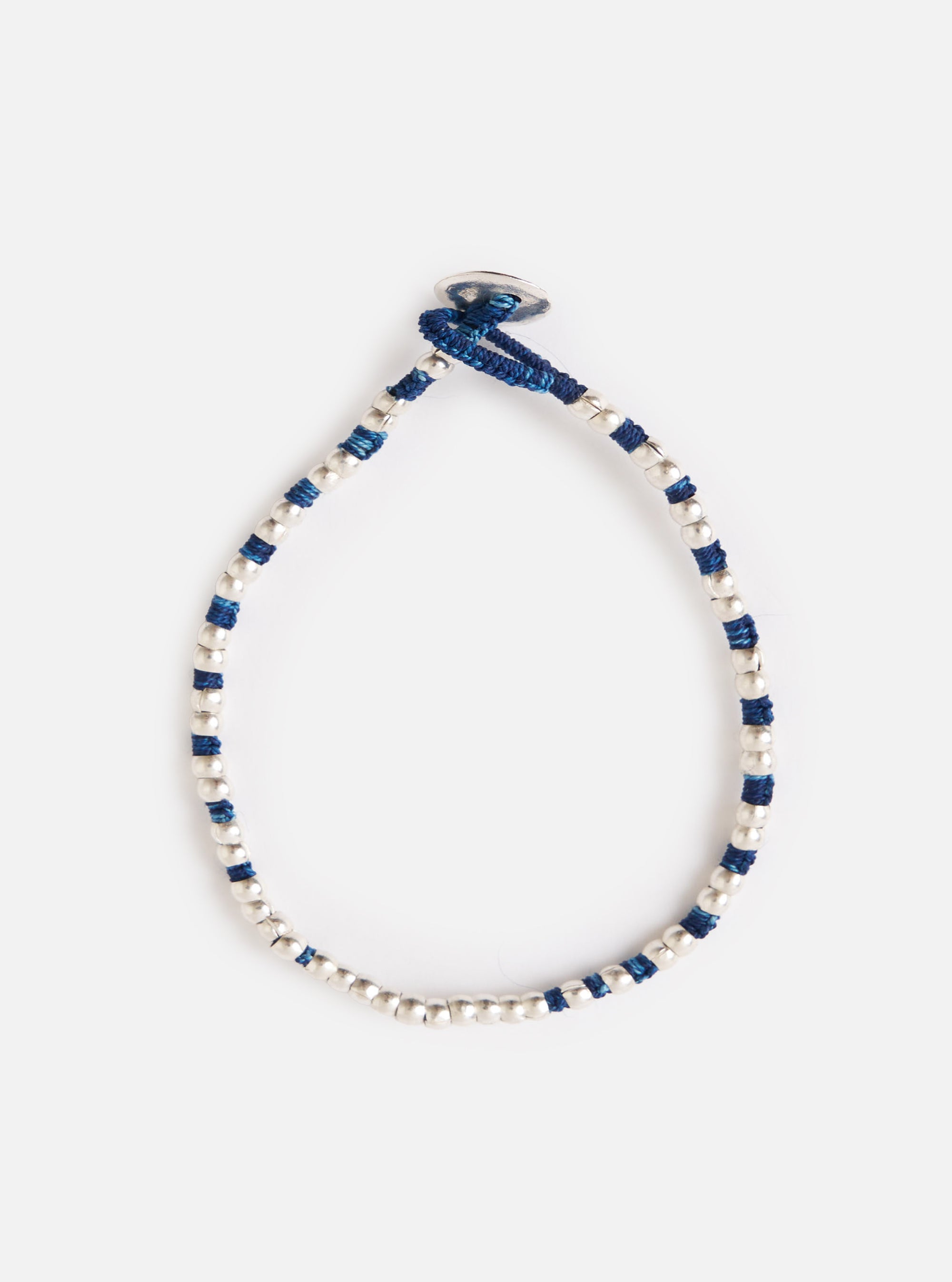 The Mikia Indigo Silver Beads Bracelet on a white background. The bracelet features silver beads and indigo-dyed string.