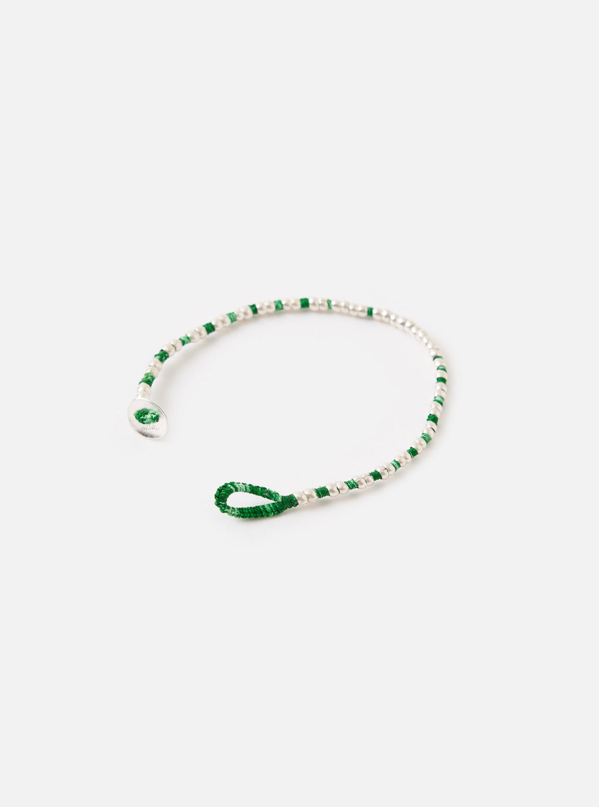 The Mikia Malachite Silver Beads Bracelet on a white surface. The bracelet features green and silver beads. The bracelet is unclasped.
