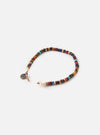 The Mikia Brown Multi Heishi Beads Bracelet on a white background. The bracelet features brown, red, and blue heishi beads strung together with a tan cord and a white button closure.