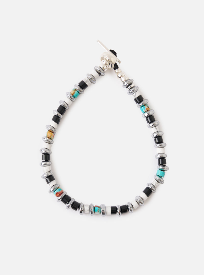 The Mikia Jet/Turquoise Hematite Roundel Bracelet on a white background. It features black, white, and turquoise beads with silver hematite accents. The bracelet is secured with a silver clasp.