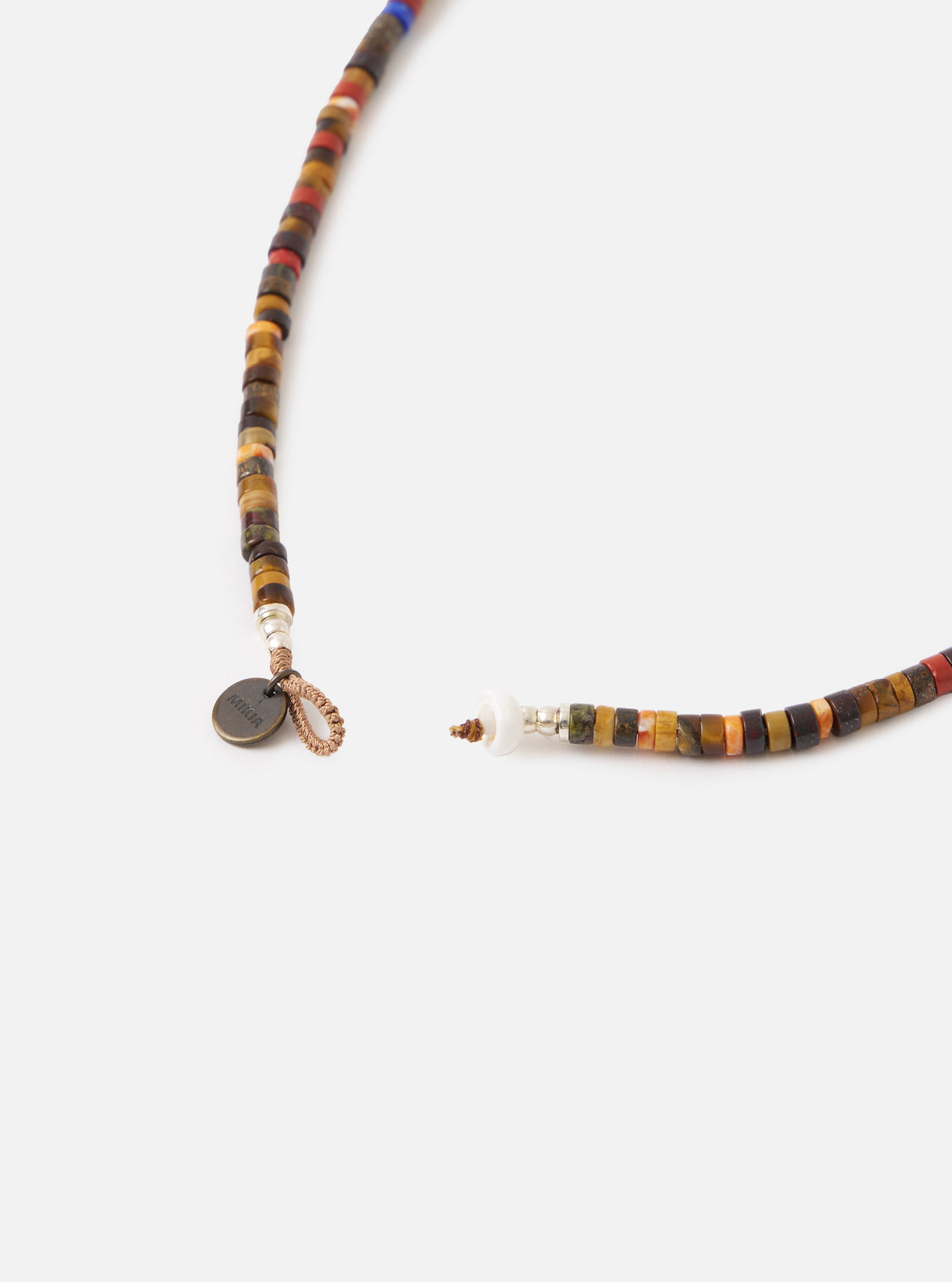 Close-up of the Mikia Brown Multi Heishi Beads Necklace on a white surface. The necklace features brown, red, and orange beads. The clasp is visible.