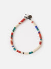 The Mikia Safari Heishi Beads Bracelet on a white surface. The bracelet features red, white, blue, and green beads. 