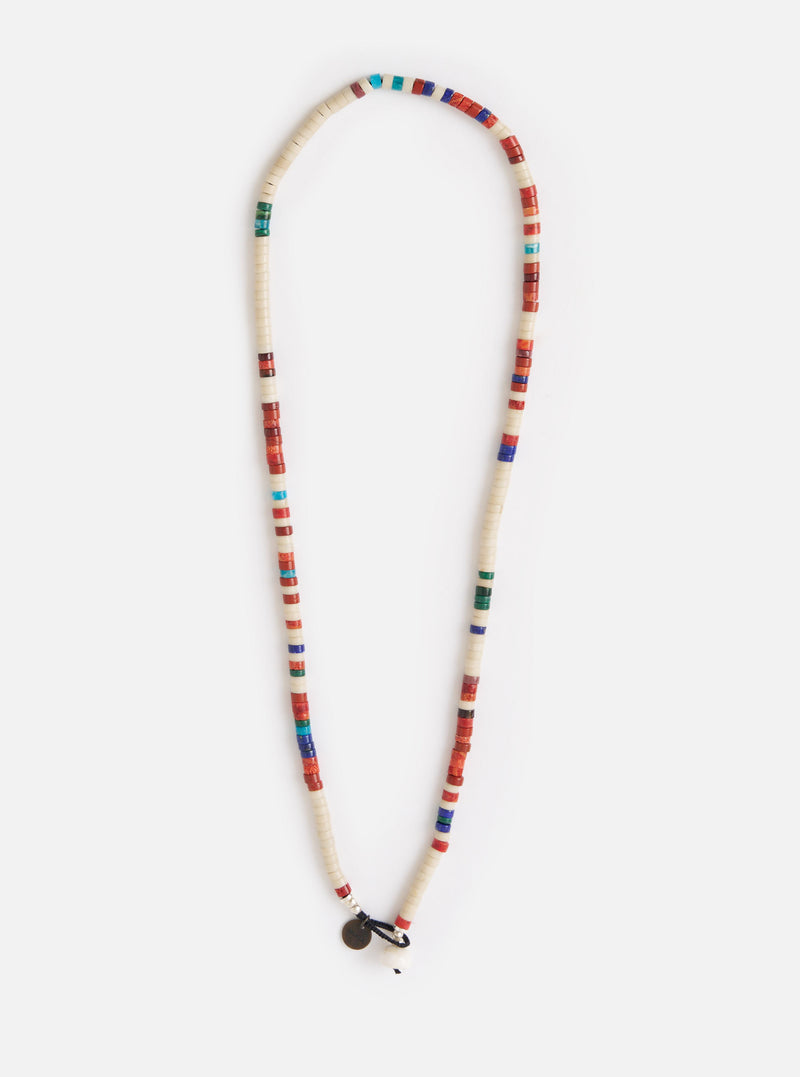 The Mikia Safari Heishi Beads Necklace on a white background. The necklace features white, red, blue, and green beads. The fit is long and the materials look like stone and glass.