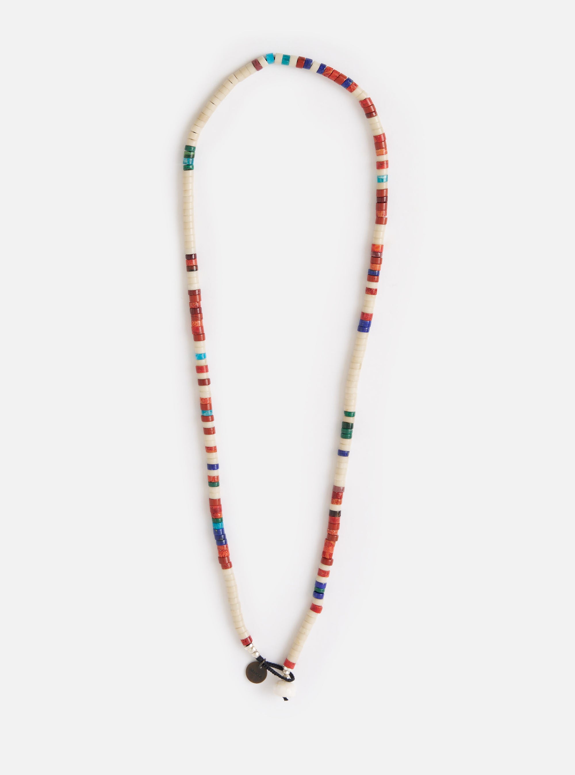 The Mikia Safari Heishi Beads Necklace on a white background. The necklace features white, red, blue, and green beads. The fit is long and the materials look like stone and glass.