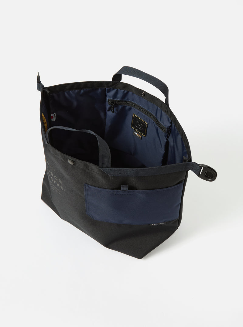 Open master-piece x Universal Works Black Recycled Tech Canvas Large Tote Bag on a white background. The bag has black canvas exterior, navy blue accents and interior.