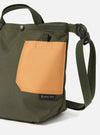 Close-up of the master-piece x Universal Works Olive Recycled Tech Canvas Small Tote Bag. It features olive green canvas with a tan pocket, set against a bright white background.