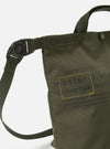 Close-up of the master-piece x Universal Works Olive Recycled Tech Canvas Small Tote Bag. The olive green bag features black lettering and straps, set against a clean white background.
