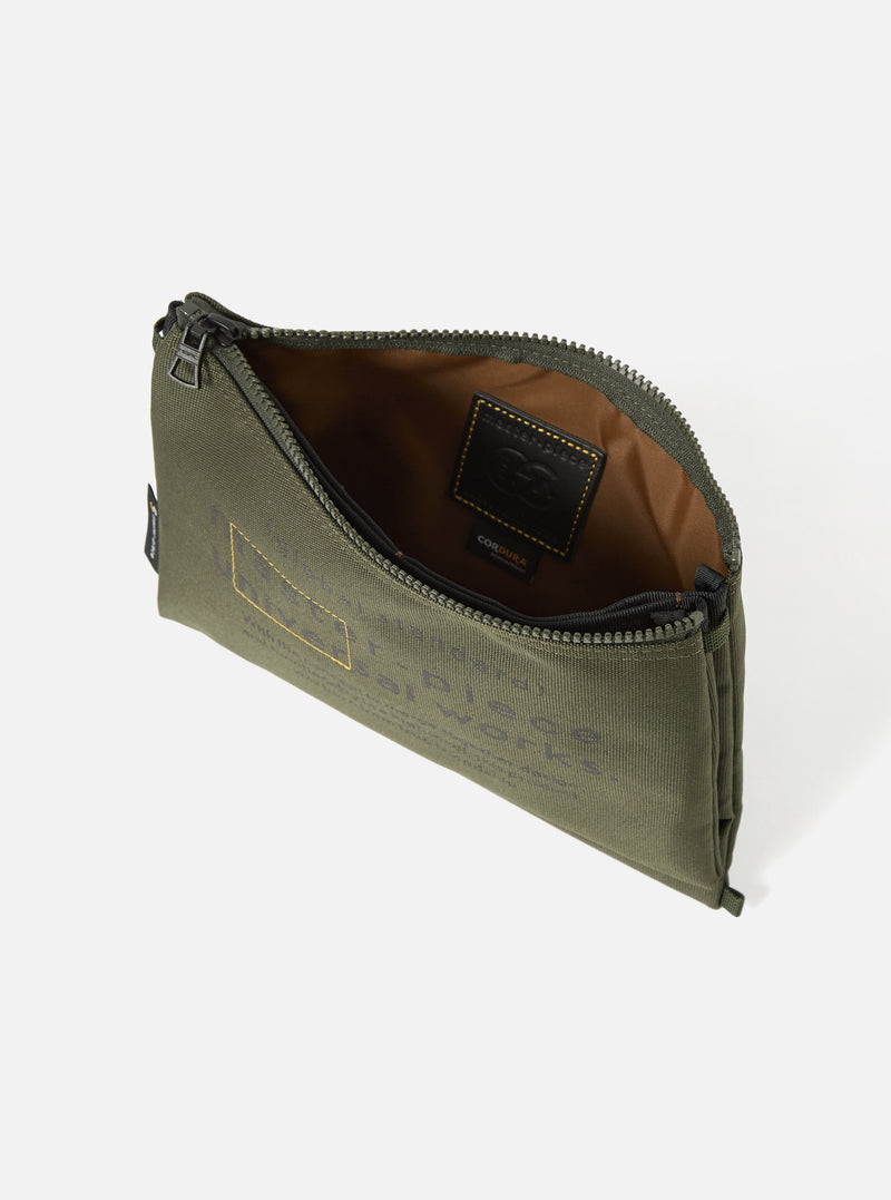 Olive master-piece x Universal Works Recycled Tech Canvas Sacoche. The bag is on a white surface, showing the inside lining and zipper. The canvas has printed text.