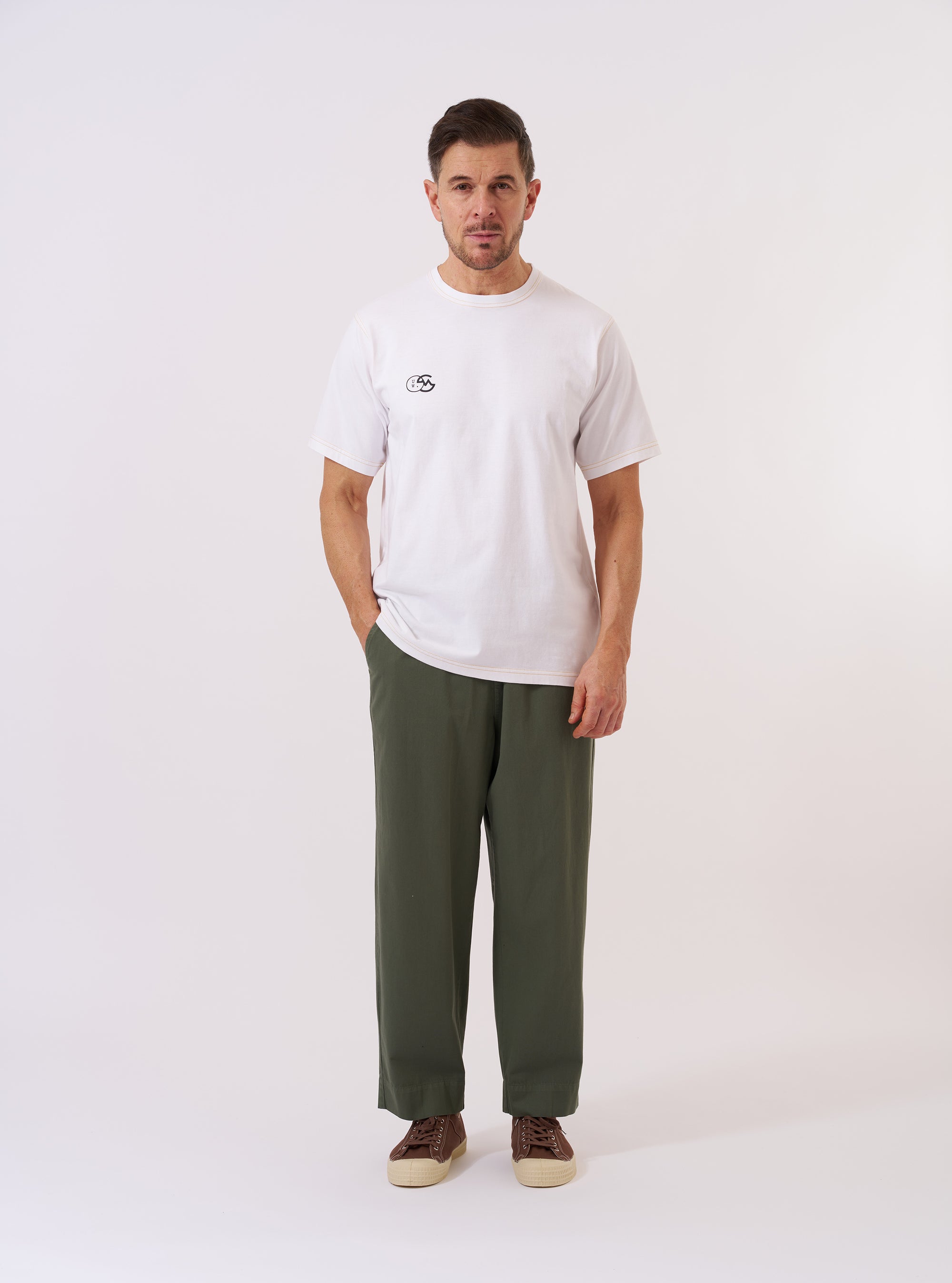 The master-piece x Universal Works White Single Jersey Print Tee is shown as a flat lay against a white background. The T-shirt features a large graphic print on the front and a classic ribbed crew neck.