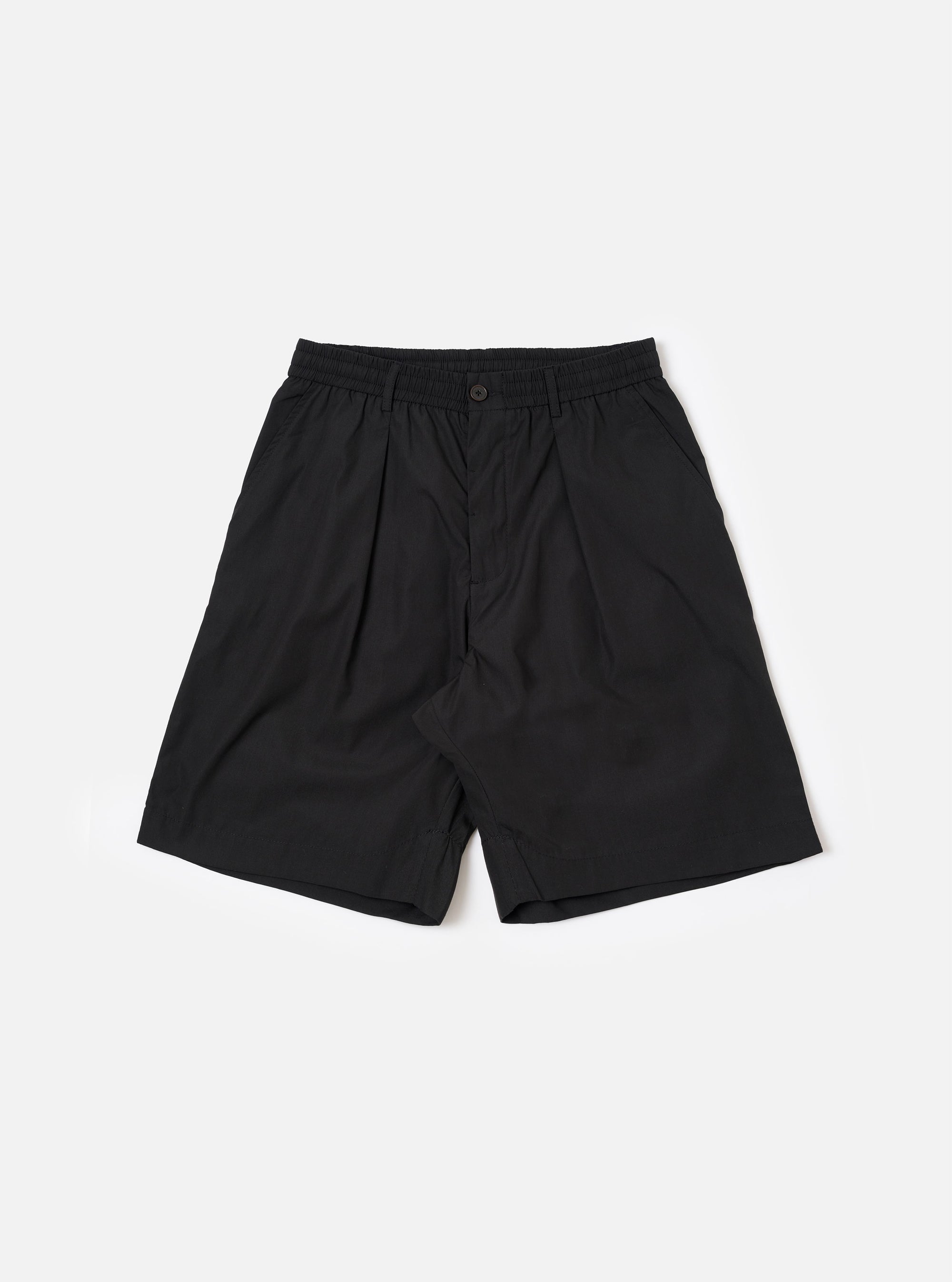 The master-piece x Universal Works Black Recycled Poly Tech Pleated Track Short is shown as a flat lay against a white background. The shorts feature a relaxed, loose fit with a single pleat on each leg and an elasticated waistband. The design includes a button closure, zip fly, and two side hand pockets.