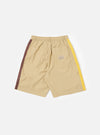 The master-piece x Universal Works Sand Recycled Poly Tech Pleated Track Short is shown from the back as a flat lay against a white background. The image highlights the two rear pockets, including one with a button-down flap, and the elasticated waistband. The sand-colored fabric has a smooth, utilitarian finish.