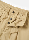 The master-piece x Universal Works Sand Recycled Poly Tech Pleated Track Short is shown from a rear three-quarter angle as a flat lay against a plain white background. The image highlights the relaxed fit, the elasticated waistband with a white drawstring, and a single rear welt pocket.
