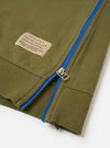 The master-piece x Universal Works Olive Brush Back Sweat S/S Billy Sweat is shown from the back as a flat lay against a plain white background. The short-sleeved sweatshirt features a ribbed crew neck and a straight hem. A small, square collaborative logo patch is positioned on the upper center of the back.