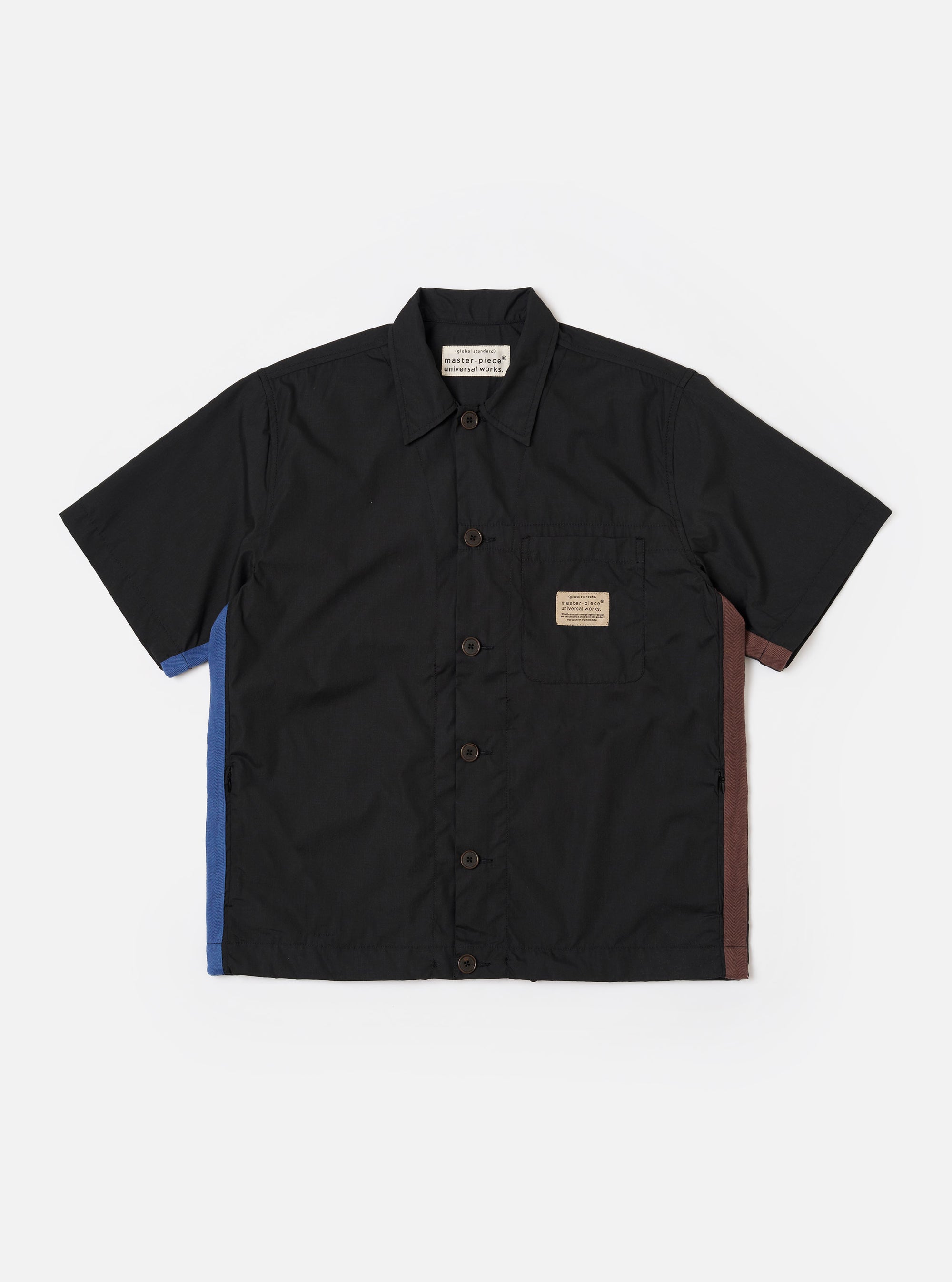 The master-piece x Universal Works Black Recycled Poly Tech Tech Overshirt is shown as a flat lay against a plain white background. The overshirt features a one-piece collar, a full button-down front, and a reinforced chest pocket on the left side. The black recycled polytech fabric has a smooth, technical finish.
