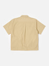 The master-piece x Universal Works Sand Recycled Poly Tech Tech Overshirt is shown from the back as a flat lay against a plain white background. The image highlights the clean lines of the sand-colored technical fabric, a straight hem, and a back yoke with a central box pleat for added movement.