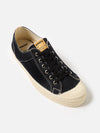 Studio shot of a Novesta for Universal Works Black Canvas Star Master shoe. The black canvas upper contrasts with the off-white rubber sole. The background is a clean, bright white.