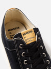 Close-up of the Novesta for Universal Works Black Canvas Star Master shoe. Features black canvas, white stitching, and black laces. The background is a clean, white surface.
