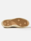 Close-up of the sole of a Novesta for Universal Works Black Canvas Star Master shoe. The sole is tan with a ridged pattern. Shot on a white background.