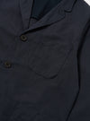 Close-up of the Navy Linen Slub Weave Three Button Jacket. The jacket is navy with brown buttons and a pocket. The background is a plain white.