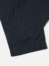 Close-up of the Navy Broadcloth Oxford Pant on a white surface. The dark navy fabric shows subtle texture and clean lines.