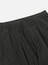 Close-up of the Charcoal Fine Linen Mix Pleated Track Pant on a white background, showing the waistband, button, and pleats.