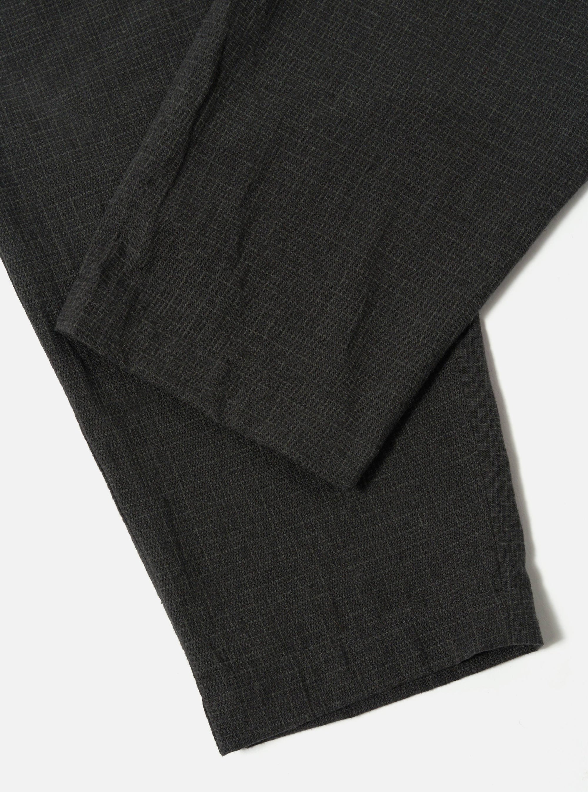 Close-up of the Charcoal Fine Linen Mix Pleated Track Pant on a white surface. The fabric shows a subtle texture and pleated details.