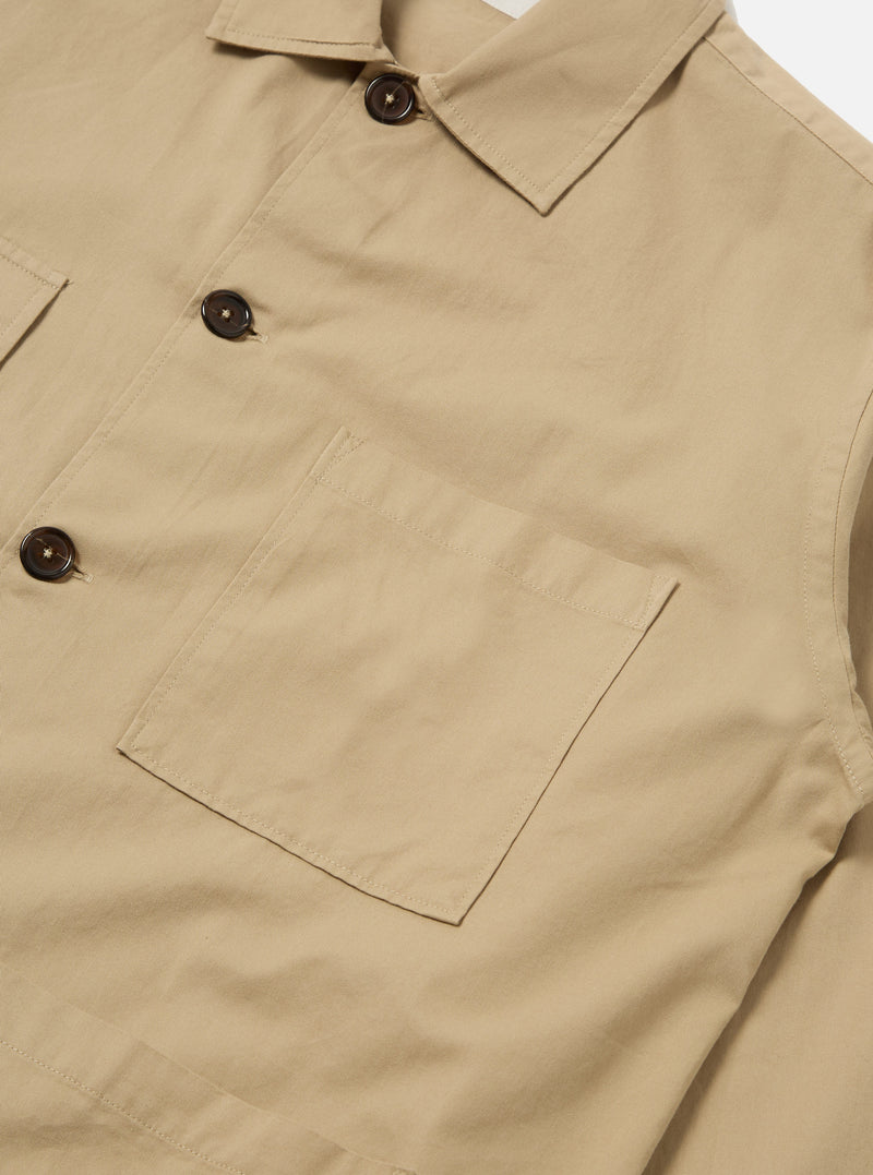 Close-up of the Sand Military Cotton Dockside Overshirt, showcasing its sand color, cotton material, button details, and pocket. Shot on a plain white background.