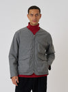 A model poses in a Charcoal Organic Chambray Parachute Liner Jacket against a white backdrop. The jacket is gray with a zip front and pockets.