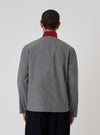 Back view of a model wearing the Charcoal Organic Chambray Parachute Liner Jacket. The jacket is gray with a red collar, set against a plain white background.