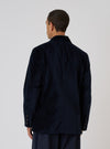 Back view of a model wearing a Navy Velveteen Manor Jacket. The jacket is a rich navy color and has a classic fit. Shot against a plain white background.