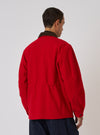 Back view of a model wearing a Red Mowbray Military Fatigue Jacket. The jacket is bright red with a brown corduroy collar. Shot against a plain white backdrop.