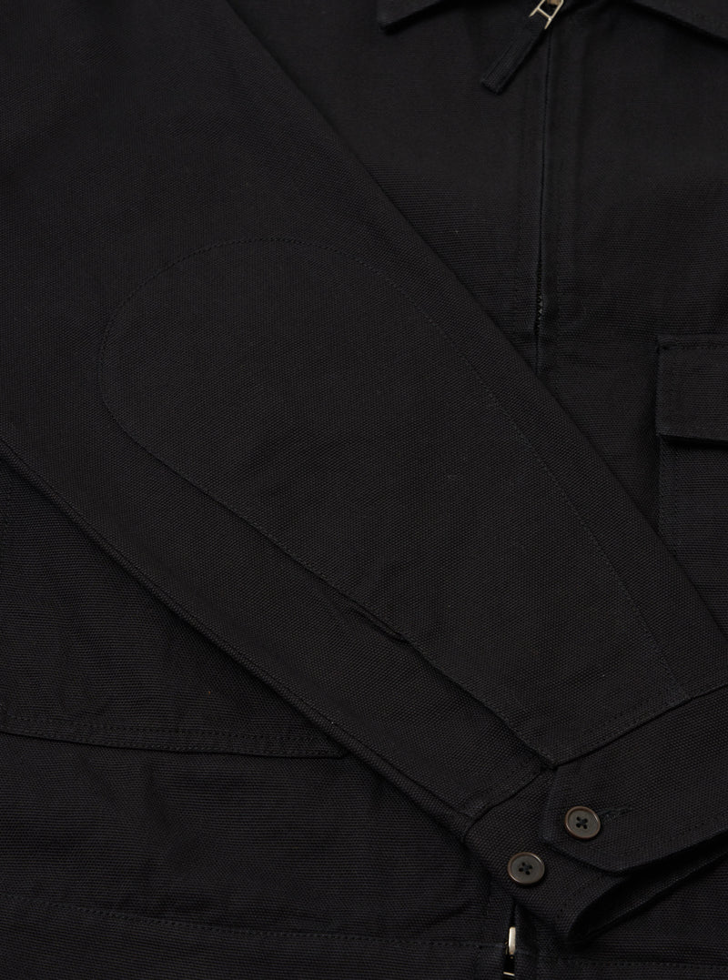 Close-up of the sleeve of a Black Organic Canvas S130 Jacket, showing the elbow patch, buttons, and canvas texture. Shot on a plain background.
