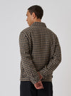 A man in a Sand Cortina Tweed Windcheater, back view. The jacket is brown and black tweed. The background is a plain white studio backdrop.