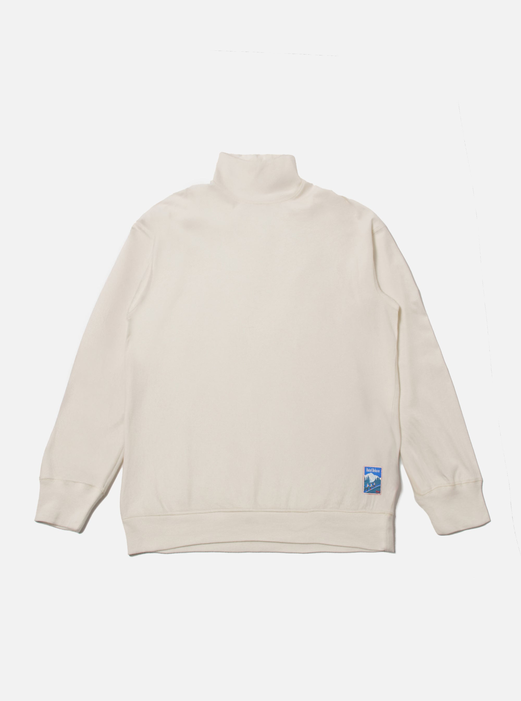 The Ecru Single Jersey Funnel Neck Tee, laid flat on a white background. The tee is a light cream color and has a funnel neck. A small blue logo is on the lower left.
