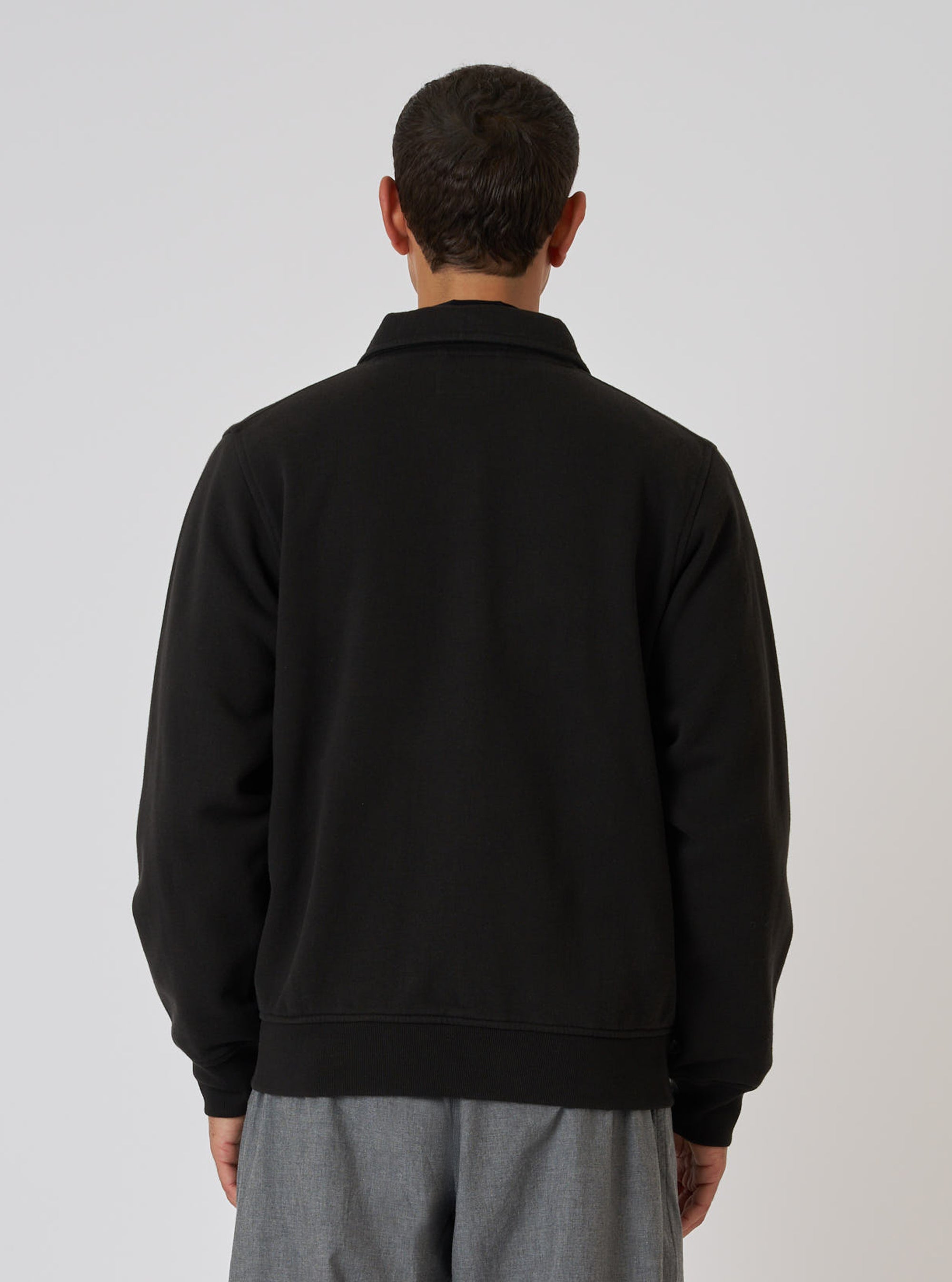 Back view of a model wearing the Black Brush Back Sweat Tyler Sweat Jacket. The jacket is black and the background is white.