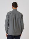 Back view of a model wearing a Charcoal Organic Chambray Patched Lazy Day Shirt. The shirt is gray and made of chambray. The background is a plain white studio backdrop.