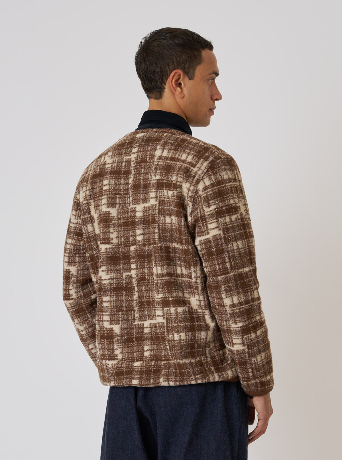 Profile of a model in a Sand Patch Check Fleece Cardigan. The brown and cream check cardigan is on a white background.
