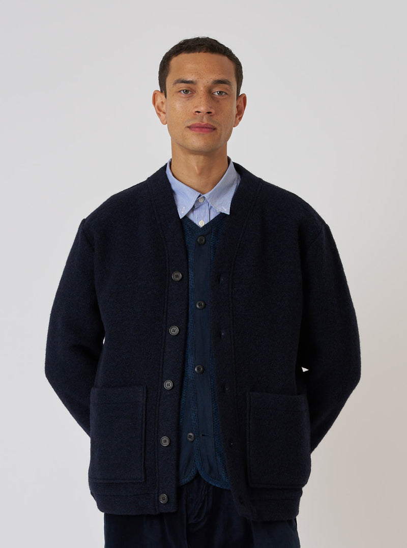 A model poses in a Navy Wool Fleece Advance Cardigan. The cardigan is a deep navy color and made of a textured wool fleece. The background is a plain white.