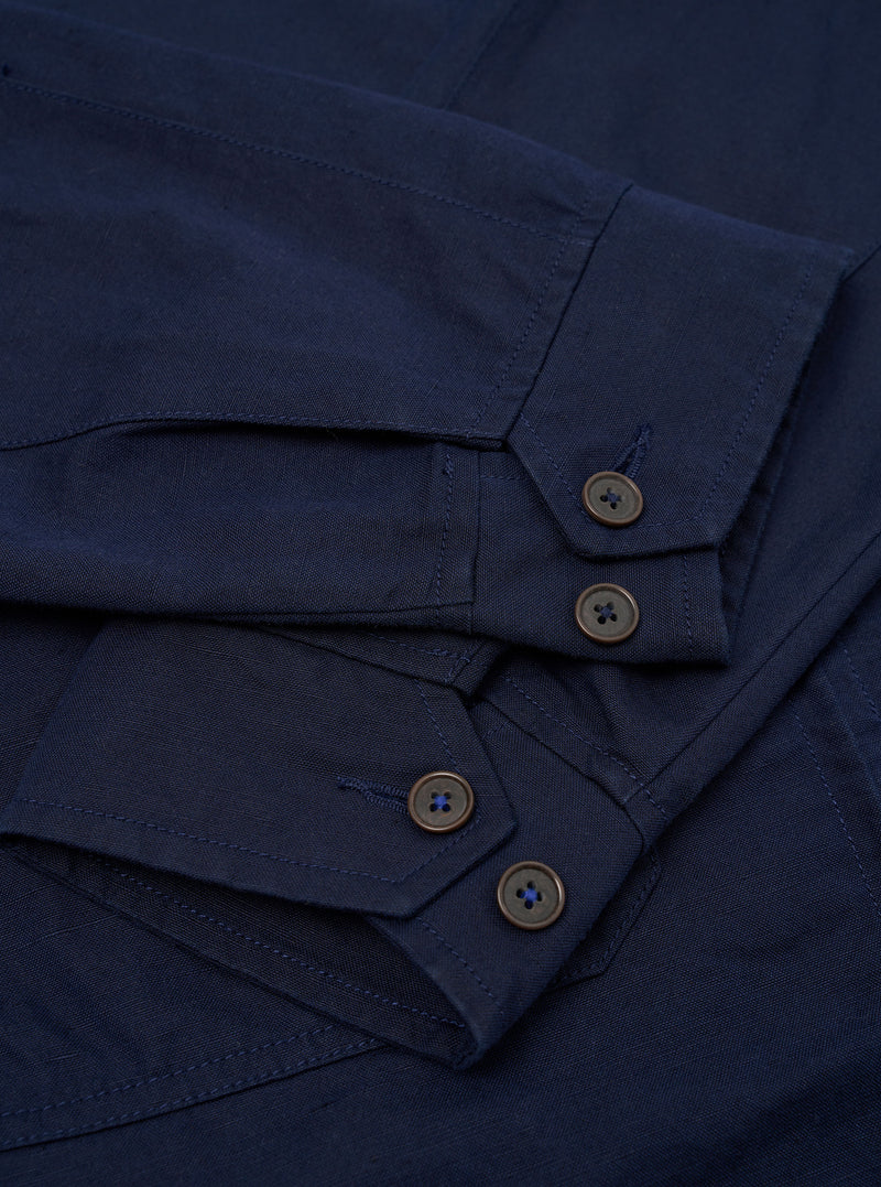 The Navy Linen Slub Weave E130 Jacket is shown from the back, laid flat against a solid white background. The image highlights the jacket's simple, clean construction, featuring a straight hem and a classic collar.