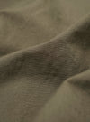 A close-up fabric swatch of the Olive Linen Slub Weave Two Button Jacket shows the textured, olive-green material. The weave features a distinct slubby appearance with horizontal and vertical lines characteristic of linen.