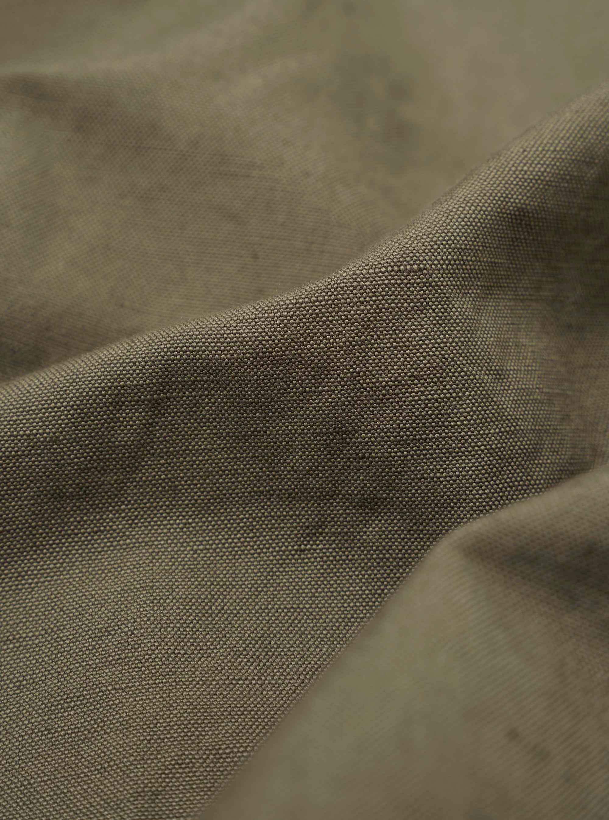 A close-up fabric swatch of the Olive Linen Slub Weave Two Button Jacket shows the textured, olive-green material. The weave features a distinct slubby appearance with horizontal and vertical lines characteristic of linen.